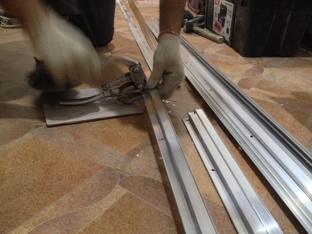 Процесс прокалывания отверстий в алюминиевом багете для натяжного потолка.
